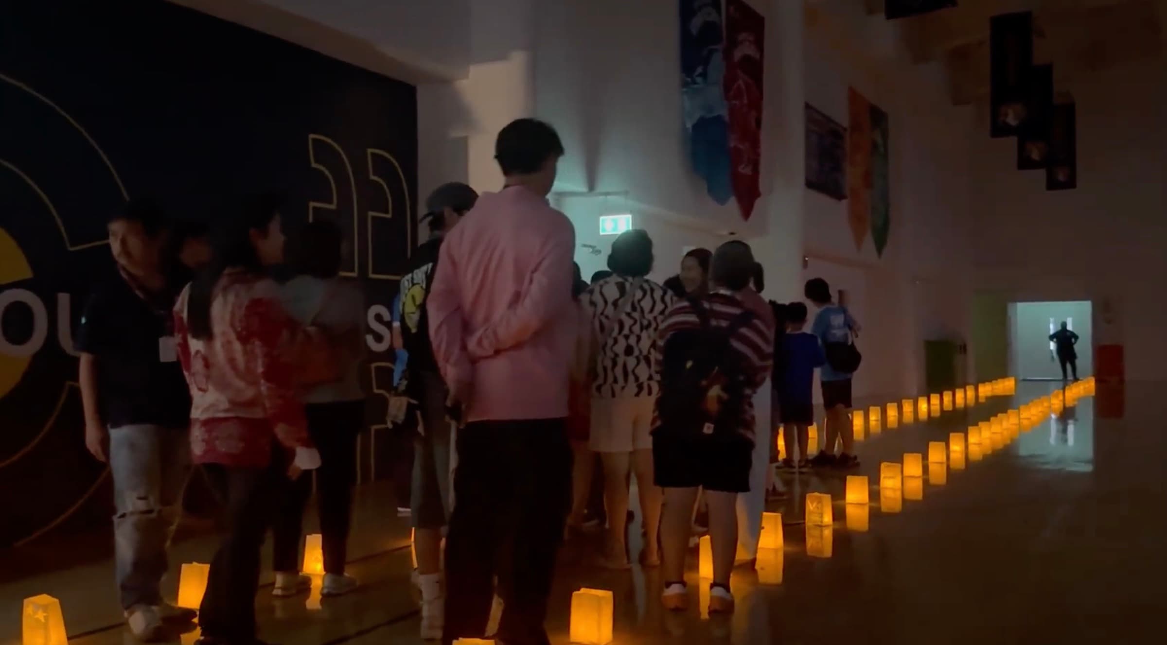 Guests walking a lantern-lit corridor at Open World 2025